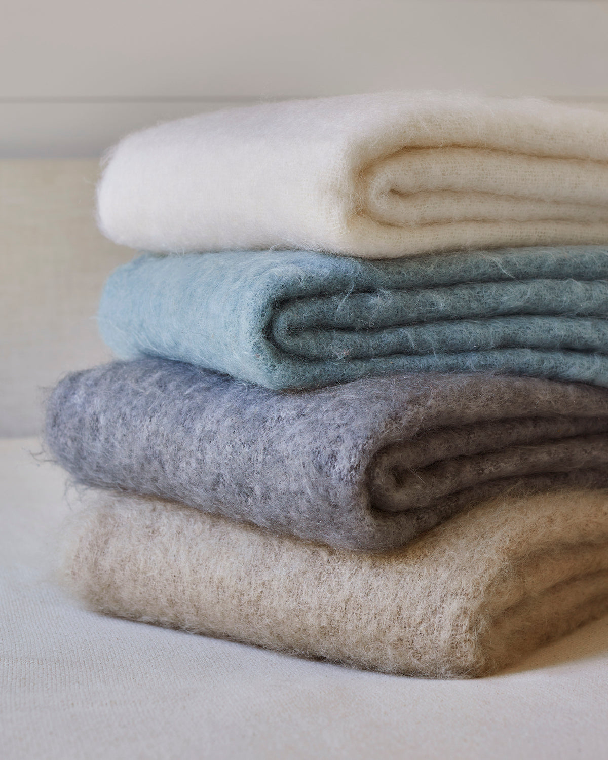 Blue and Neutral stack of New Zealand Mohair throw blankets