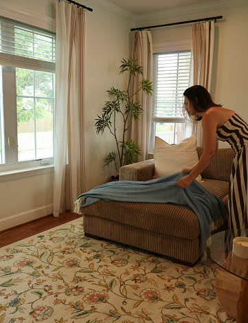 italian herringbone throw in chambray being styled on a couch by a woman