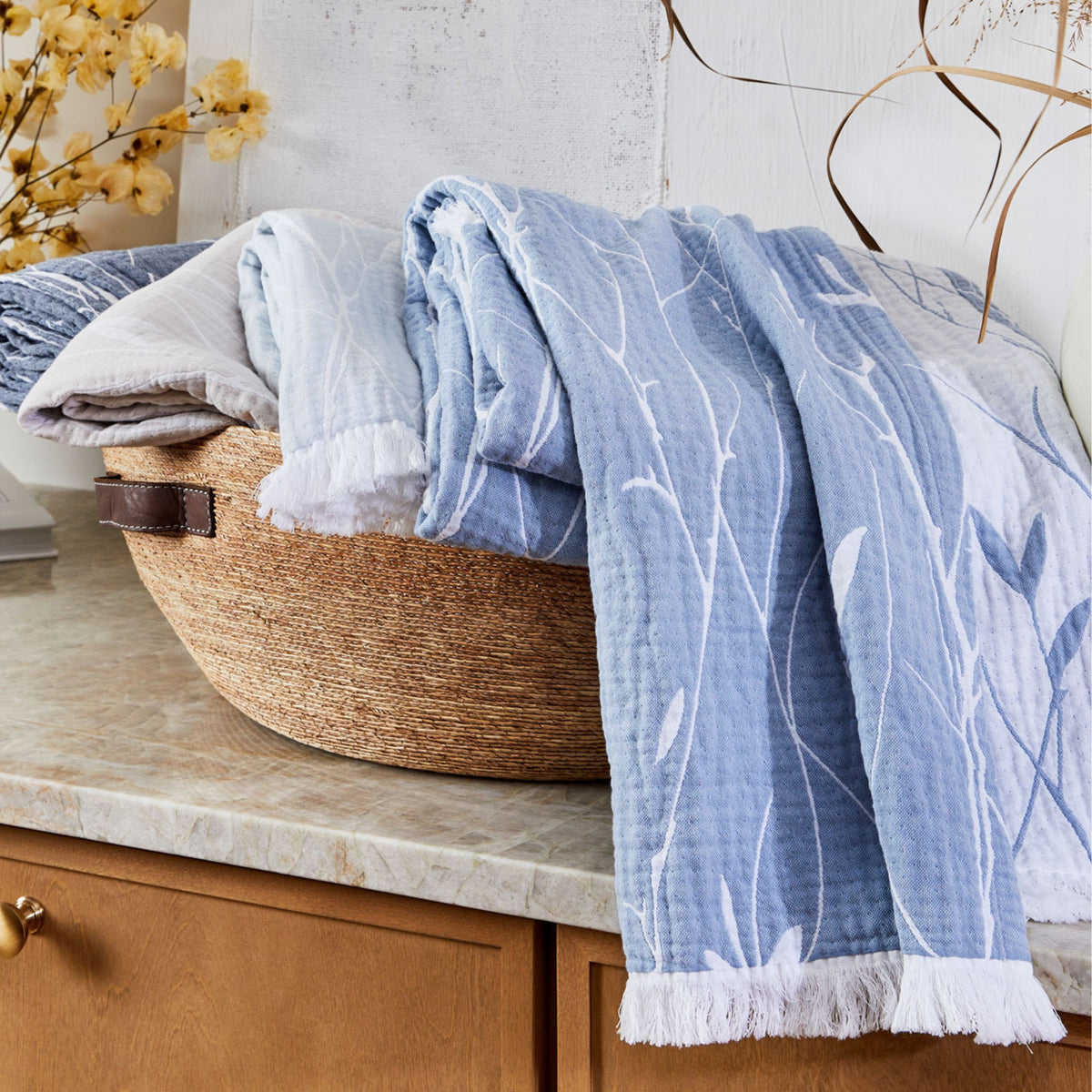 cotton throw blanket with floral pattern in a basket