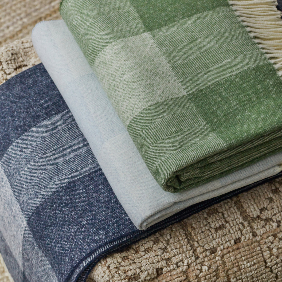 hampton plaid herringbone throw blanket stack in navy, hydrangea, and olive